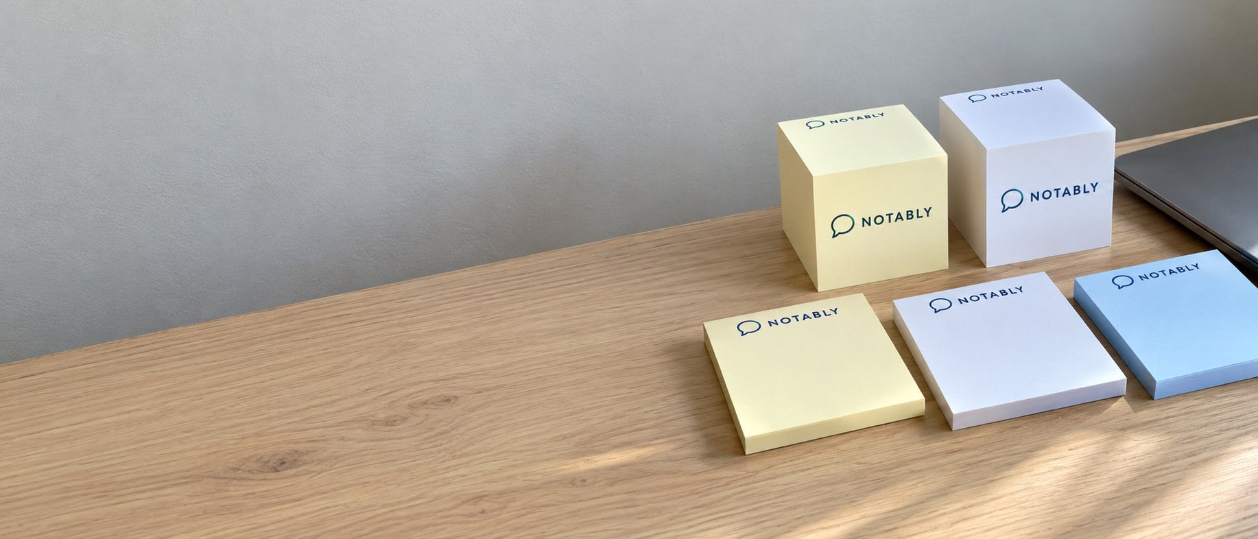Branded sticky note pads and cubes stacked on a desk